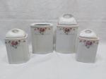 Toucador com 4 peças em porcelana Rami com guirlanda floral vermelha. Medindo o maior 12cm x 11cm x 16,5cm de altura. Leve bicado na parte interna da tampa.