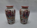 Par de pequenos vasos decorativos em porcelana oriental com pintura de gueixas. Medindo 11,5cm de altura.