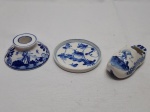 Lote composto de cinzeiro na forma de tamanco holandes, castiçal e porta copo redondo em porcelana azul e branco. Medindo o tamanco 9,5cm de comprimento.