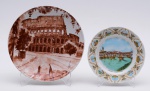 Dois pratos decorativos em porcelana italiana representando paisagens da Itália. Marcas das manufaturas Saturnia e A.G.L. Diâmetros: 20 cm e 27 cm.