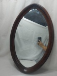 Lindo espelho oval em cristal bisotado com moldura em madeira de jacaranda, atribuído Sérgio Rodrigues. Medindo a moldura 72cm x 45cm.