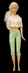 Antiga Barbie original Mattel toda articulada, com um cropped, uma calça em tom verde com flores.