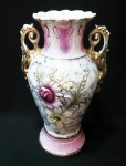 Grande ânfora da década de 50 em porcelana esmaltada e vitrificada com bela policromia e flores em relevo. Hastes em volutas e acantos douradas. Matizes de cinza, rosa e bordô. Altura de 28 cm e base de 12 cm.