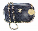 CHANEL - bolsa tiracolo vintage em couro negro matelassê em losangos made in France. Etiqueta no interior. Peça usada e interior com perdas pelo tempo de uso. Logomarca em metal dourado e corrente dourada entrelaçada com couro. Medalha da marca em um dos fechos. Outro fecho sem a pega mas funcionando normal. Bolso interno com ziper. Bom estado externo. Medidas: 21 x 13 cm e fundo com 7,5 x 21 cm. Venda no estado.