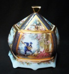 Porcelana "D.P" - porta jóias c/ presentoir em porcelana com frisos e arabescos em cenas galantes de fundo azul claro. Feito à mão. Mede 15 de altura e o presentoir com 15 x 12 cm.