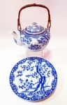 Conjunto de 2 peças para chá sendo um bule de porcelana oriental "Japan" com alça de junco cores azul e branco com decoração em ramos de flores tendo filtro interno de porcelana de 17 cm e prato no mesmo feitio com 16 cm.