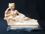 Decorativa escultura italiana na figura de Paolina Bonaparte recostada em divã material poliester sobre base em mármore escuro rajado. Marca "G.R." na parte posterior da peça. Medidas: 11 de altura e 14 x 5 cm.