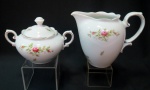 Conjunto para servir em porcelana "Renner" branca decorado com rosas e miguês salpicados. Composto de 1 leiteira com alça medindo 14 cm e açucareiro com 12 cm de altura.