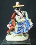 Escultura mexicana de Talavera, pintada a mão e ricamente policromada com detalhes dourados. Casal em dança festiva regional. base oval de 11 x 7 cm. Altura de 17 cm.