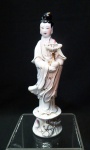 Estatueta em porcelana branca chinesa "Kuan Yin" com frisos dourados e rosa , manto em belo panejamento, marca na base. Altura de 14 cm.