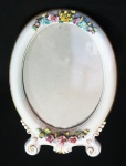 Vista Alegre - porta retrato oval em porcelana brnca filetado a ouro com flores e ramos em relevo policromados (mínimas perdas pelo tempo). Para pendurar. Medidas: 24 x 17 cm.