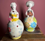 Duas bonecas em cerâmica  com pinturas coloridas. -Medidas: - c/ chapéu  - 21 x 10 cm - S/ chapéu   - 20  x 10 cm