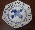 Pequeno centro de mesa / prato decorativo em porcelana branca decorada com motivo floral em azul e detalhes vazados nas bordas - Altura 4 cm e Diâmetro: 19 cm