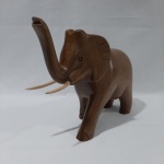 Escultura em madeira elefante com presas. Medidas aproximadas: 23cm (a) x 30cm (c) x 9cm (p).