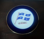 Prato de parede decorativo em porcelana "Quebec Canada" com borda azul e detalhe na borda em dourado, decorado ao centro com bandeira Quebec - Diâmetro: 16 cm