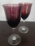 Duas taça em fino cristal colorido com pé alto na cor vinho -Altura: 18 cm - Uma taça com lascado na base,