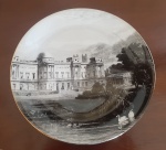 Impressionante prato em louça fina, Fine Bone China, com ilustração do Palácio de Buckingham, Inglaterra. Esta peça elegante exibe um retrato detalhado do palácio icônico, combinando artesanato superior com uma representação histórica de um dos marcos mais reconhecidos do Reino Unido. Perfeito para coleção - Diâmetro: 22 cm