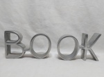 Par de serre livre, aparador de livros em alumínio, escrito "BooK". Medindo o conjunto 40cm de comprimento x 13cm de altura.