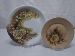 Lote de 2 pratos decorativos em porcelana floral. Medindo o maior 25,5cm de diâmetro.