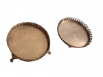 Par de salvas espessurados à prata com galerias vasadas, uma delas com fundo cinzelado e repuxado apoiado em patas de animal, sendo um deles torto, a outra com pés de bola,  Diam. 14 e 13 cm.