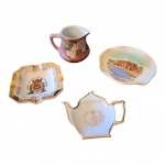 COLECIONISMO - Quatro peças em porcelanas sendo 1 jarrinha, 1 cinzeiro comemorativo IV centenário da Cidade de São Paulo, 1 prato representando Castelo del Soghi, Rapallo e um suporte para sachê de chá com brasão Imperial, Museu de Petrópolis.