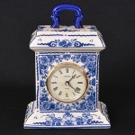 "Carriage clock (relógio de carruagem)" em ceramica policromada com motivos florais, tons de azul e branco. marca Staiger - movimento Quartz. - Obs.: Não testado, no estado  (19x8x14 / caixa: Diam 6cm)