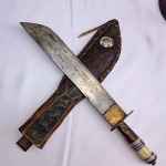 Antiga Faca / Facão com lâmina larga Cabo com materiais variados (osso, alpaca, metal amarelo e bronze). Guarda em formato de peixe. Bainha de couro marrom escuro com costuras decorativas e design padronizado, além de um laço para cinto e peça ornamental de cela de cavalo em alpaca. Aprox 45 cm de comprimento total. Detalhes conforme fotos, _(ºLº)_ Caso necessite, tire todas suas dúvidas via atendimento personalizado por WhatsApp: (11) 98681-9377 ou pelo e-mail: contato@antiguera.com.br, onde você pode solicitar fotos detalhadas. Não deixe para última hora! Antecipadamente agradecemos pelo seu lance. Sem garantias futuras