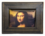 Nelson Leirner (1932-2020). NELSON LEIRNER X MONA LISA. 2004. Pendant de obra de arte e almofada. Tecido impresso revestido por espuma emoldurado por moldura de papelão impressa. 38 x 48 cm, todo o conjunto. Assinado e datado no verso da almofada Nelson Leirner 1999 + 5. Na obra, com a irreverência que sempre caracterizou seu trabalho, Leirner sugere três usos para a peça: pendurado na parede, decorando a poltrona ou servindo de cama para o cachorro (conforme ilustrado).