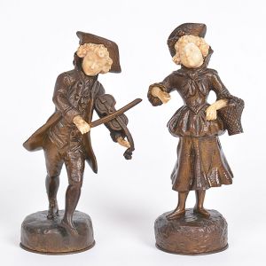 <b>GEORGES OMERTH - Conjunto de 2 esculturas </b>em bronze patinado com rostos e mãos em marfim representando menino violinista e figura de dama. Séc. XIX. Assinadas na base. Pequenos defeitos nas mãos. Alt. 15,5 e 16,5 cm