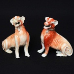 <b>Par de cães "seated hounds"</b>, em porcelana Companhia das Índias, decorados com esmalte "rouge de fer". Circa 1780. Período Qianlong. Alt. 15,5 cm; Compr. 14 cm