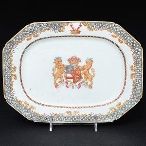 <b>Travessa </b>retangular de cantos chanfrados em porcelana Companhia das Índias ricamente decorada em policromia e ouro com brasão e timbre armoriais de Nassau, conde de Rochefort. Borda com arabescos em "grisaille" e volutas centralizando "crest". Séc. XVIII. Med. 29 x 21,5 cm