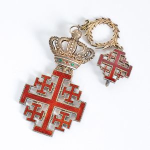 <b>Ordem dos Cavaleiros do Santo Sepulcro</b>. Comenda em cruz de travessões terminados em ponteiras perpendiculares. Entre os ângulos quatro cruzes menores. Arremate em uma coroa real decorada com flores, friso perolado e encimada por globo com cruz latina. Séc. XVIII. Alt. 14,5 cm