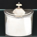 Elegante <b>"tea caddy" </b>em prata portuguesa "1º Título", feitio oval, liso e com pega da tampa em marfim. Marca do joalheiro MERGULHÃO de Lisboa. Peso 700 g. Alt. 17 cm; Compr. 15 cm