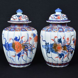 Belo <b>par de potiches </b>em porcelana "Imari", apresentam bojos gomados decorados em policromia florida em suas tonalidades características de azul índigo, "rouge de fer" e realces a ouro. Primeira metade do séc. XIX. Apresentam restauro. Alt. 31,5 cm