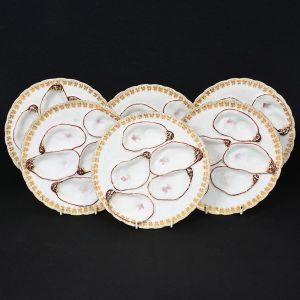 Antigo <B>conjunto de 6 pratos para ostras </b>em porcelana francesa de Limoges na cor bege e marrom com pintas "aubergine". Rebaixo para acomodar cinco unidades cada. Borda a ouro com folhas de parreira. Manufatura Haviland & Co. Diâm. 19,5 cm