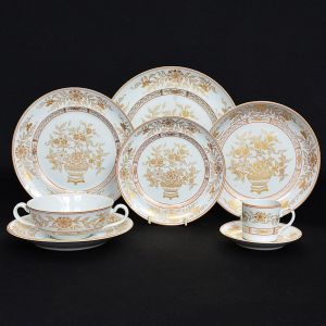 <b>Serviço de jantar e café </b>em porcelana Vista Alegre, decorado com composições floridas a ouro ao gosto da porcelana da Companhia das Índias. Fundo branco. Constando de 20 pratos rasos, 10 taças de "consommé" c/ pires, 10 pratos p/ sopa ou saladas, 10 pratos p/ entradas ou frutas, 10 pratos p/ sobremesa e 10 xícaras de café c/ pires. Marca da manufatura no verso. Total de 70 peças.