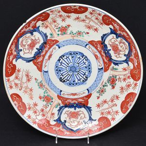 Grande <b>medalhão </b>circular em cerâmica japonesa "Imari", decorado com composições floridas no estilo característico predominando as tonalidades de azul índigo e "rouge de fer". Verso com os elementos do padrão. Séc. XIX. Diâm. 40,5 cm