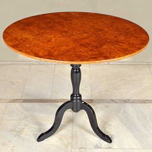 Antiga <b>mesa circular "Biedermeier"</b> com tampo em raiz de nogueira sobre base patinada de negro e pernas trípodes arqueadas. Alt. 76 cm; Diâm. 94 cm