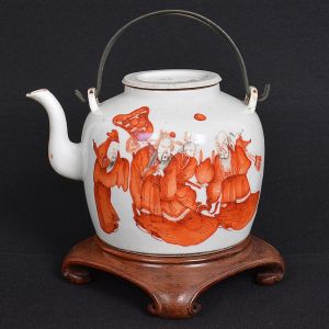 Antigo<b> bule para chá </b>em porcelana chinesa decorada com figuras de nobres, em "rouge de fer", sobre fundo branco. Alça metálica. Marca na base. Acompanha base em madeira. Alt. sem a base 14 cm