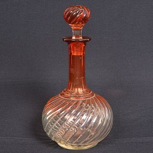 <b>Licoreiro </b>em cristal BACCARAT moldado em frisos retorcidos, em "dégradée" rosado. Gargalo alongado e chanfrado, modelo "Bambou Tors". Alt. 30 cm