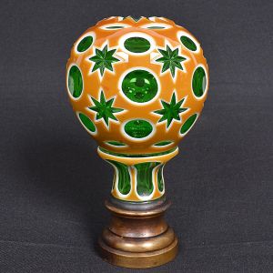 <b>Pinha</b> globular francesa em cristal verde esmeralda com "overlay" em âmbar e branco. Lapidação com círculos e elementos estrelados. Base em bronze. Séc. XIX. Alt. 17,5 cm