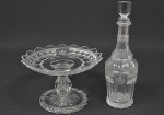 Raríssimo <b>conjunto de fruteira e garrafa </b>em cristal BACCARAT que pertenceram ao Segundo Serviço Imperial. A fruteira apresenta reserva octogonal projetada sobre uma de suas facetas com as armas do Império. O pé termina em torçal. Borda do prato em bicos. A garrafa segue o mesmo padrão decorativo, também trazendo as armas da casa de Bragança. Peças idênticas no Museu Imperial de Petrópolis. A garrafa apresenta mofo. A fruteira apresenta mínimos bicados nas pontas. Alt. da garrafa 31 cm; Alt. da fruteira 15,5 cm; Diâm. da fruteira 23,5 cm