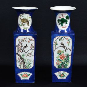 Belo <b>par de vasos</b> em porcelana chinesa do séc. XIX policromados e decorados, cada lado, com reservas de paisagens, pássaros, aves entre ramagens e outras menores, em forma de leques. Gargalos em corneta com tigres e quimeras. Fundo com ideogramas. Dois pequenos lascadinhos no verso do bocal de um deles. Alt. 40,5 cm