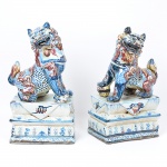 <b>Casal de cães de fó </b>em porcelana chinesa, decorados em esmaltes de tonalidade "sangue de boi" e azul índigo e apoiados em elemento almofadado decorado com estilizações. Séc. XIX. Med. 61 x 26,5 x 18 cm