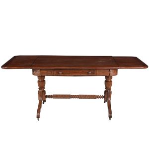 Belíssima <b>mesa colonial</b> brasileira em jacarandá claro. Tampo retangular com duas abas reclináveis sobre estrutura almofadada com cantos boleados e pequenas aplicações circulares em marfim. Gaveta na parte anterior. Apoios laterais em colunas torneadas e gomadas. Pernas recurvadas e frisadas unidas por travessão com entalhes losangulares e anelados. Pés em rodinhas. Primeiro quartel do séc. XIX. Med. fechada 80 x 120 x 100 cm