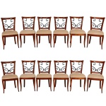 <b>Conjunto de 12 cadeiras</b> europeias no estilo Biedermeier em madeira nobre com espaldares decorados com traves metálicas movimentadas, pernas levemente recurvadas e assentos em linhão bege. Alt. 89 cm