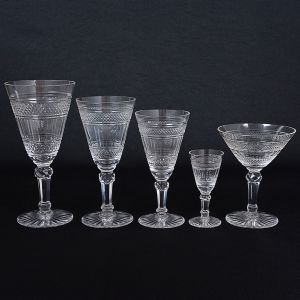 <b>Serviço em belo cristal francês</b> lapidado em geometrizados. Constando de 10 copos p/ água (alt. 18 cm), 10 taças de champanhe, 12 copos p/ vinho tinto, 10 copos p/ vinho branco, 12 cálices p/ licor, 12 taças p/ sorvete, 12 lavandas, 10 pratinhos de pão (diâm. 16 cm) e 12 robustas taças p/ sobremesas (alt. 9,5 cm e diâm. 13 cm). Total de 100 peças.