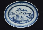 <b>Travessa </b>oval para assados em porcelana chinesa do séc. XVIII, decorada em azul índigo "underglaze" com paisagem lacustre e casario. Borda em arabescos. Séc. XVIII. Med. 41,5 x 34 cm