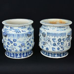 <b>Par de jardineiras</b> circulares em porcelana chinesa, decoradas com arabescos, estilizações e relevos em azul índigo "underglaze" sobre fundo branco. Alt. 35 cm; Diâm. 32 cm