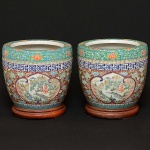 <b>Par de jardineiras</b> em porcelana japonesa "Hibachi Style Imari" em rica policromia com reservas de paisagens montanhosas com pagodes. Restante das peças preenchido por composições de flores e arabescos geometrizados. Início do séc. XX. Alt. 24,5 cm; Diâm. 27 cm